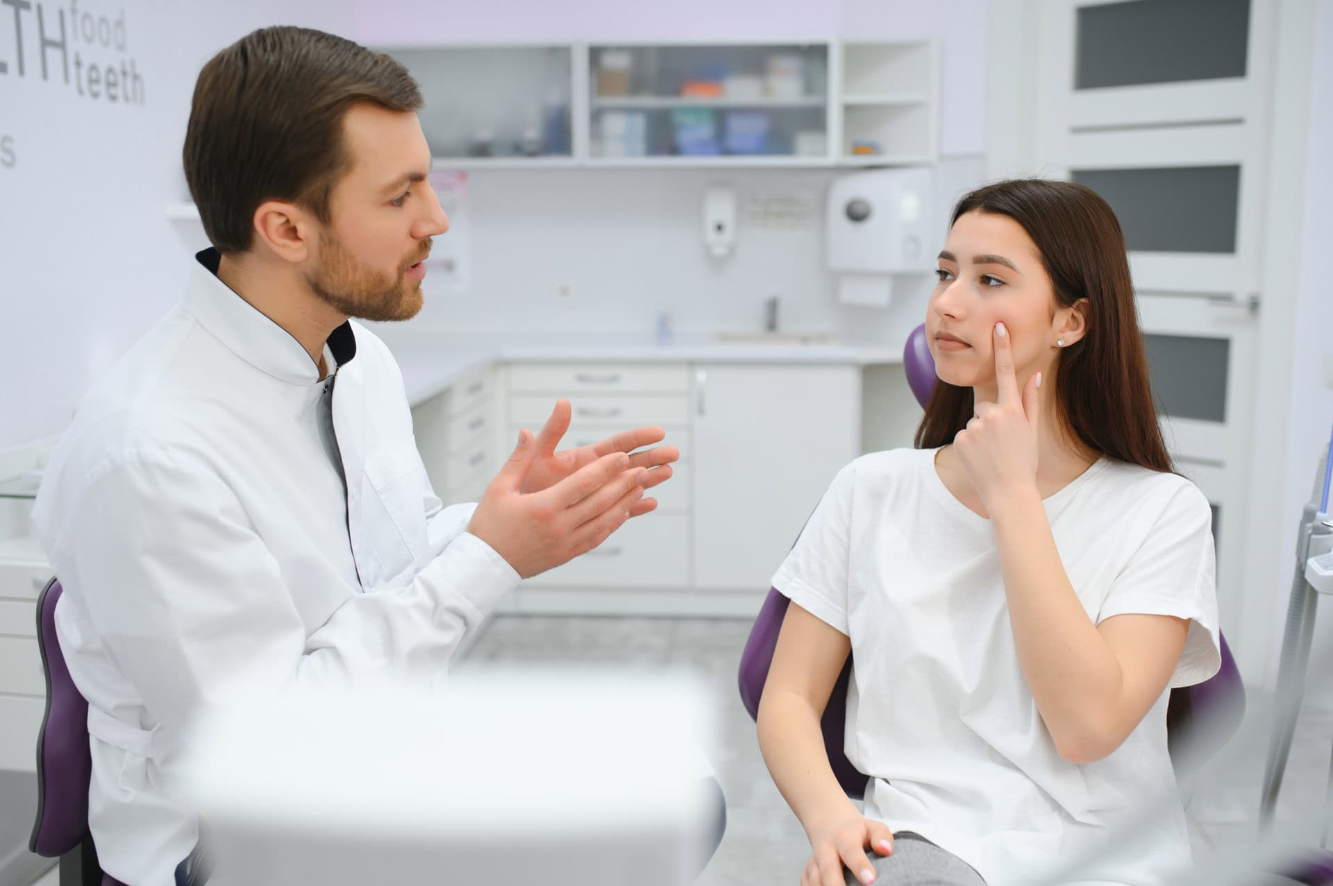 girl explaining dental problem to dentist